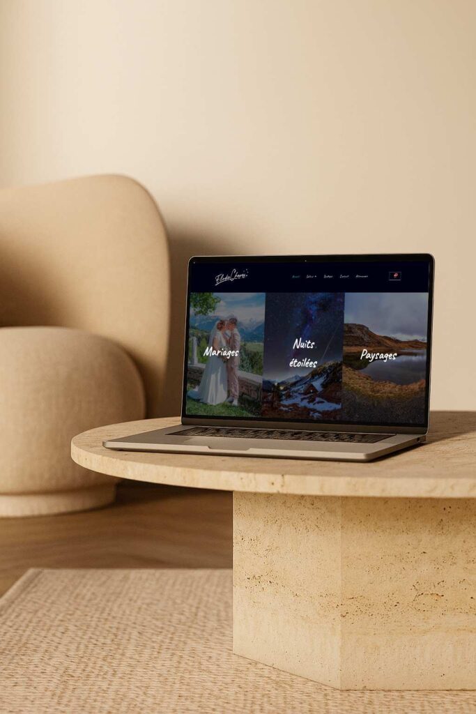 Ordinateur portable sur une table, affichant un site web de photographe avec catégories mariages, nuits étoilées et paysages.