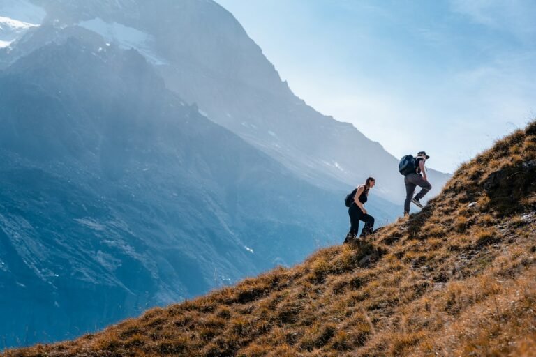 Deux randonneurs gravissant une pente en montagne, activité outdoor